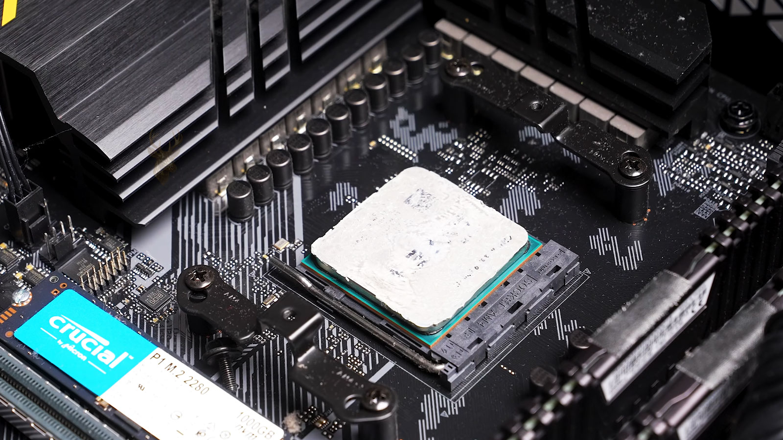 Desktop motherboard with processor installed showing dried thermal paste during overheating diagnostics