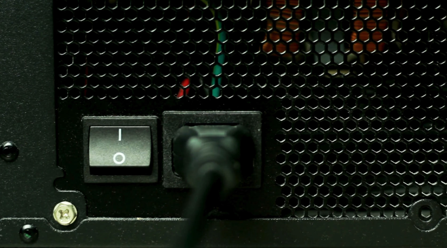 Rear view of a desktop computer power supply connected to a power cable during PC hardware diagnostics