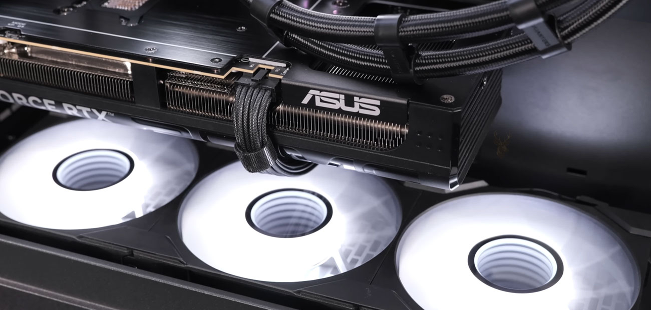 ASUS RTX graphics card installed inside a desktop PC with illuminated cooling fans and internal performance hardware