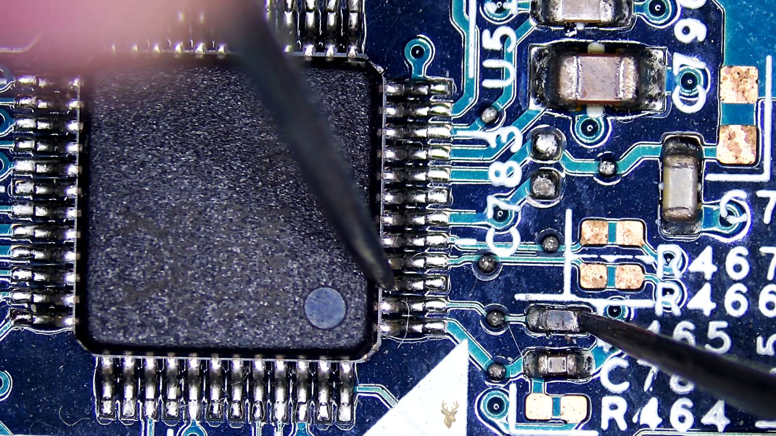 Computer circuit board with a large 48-pin IC being measured from one pin to a nearby resistor.