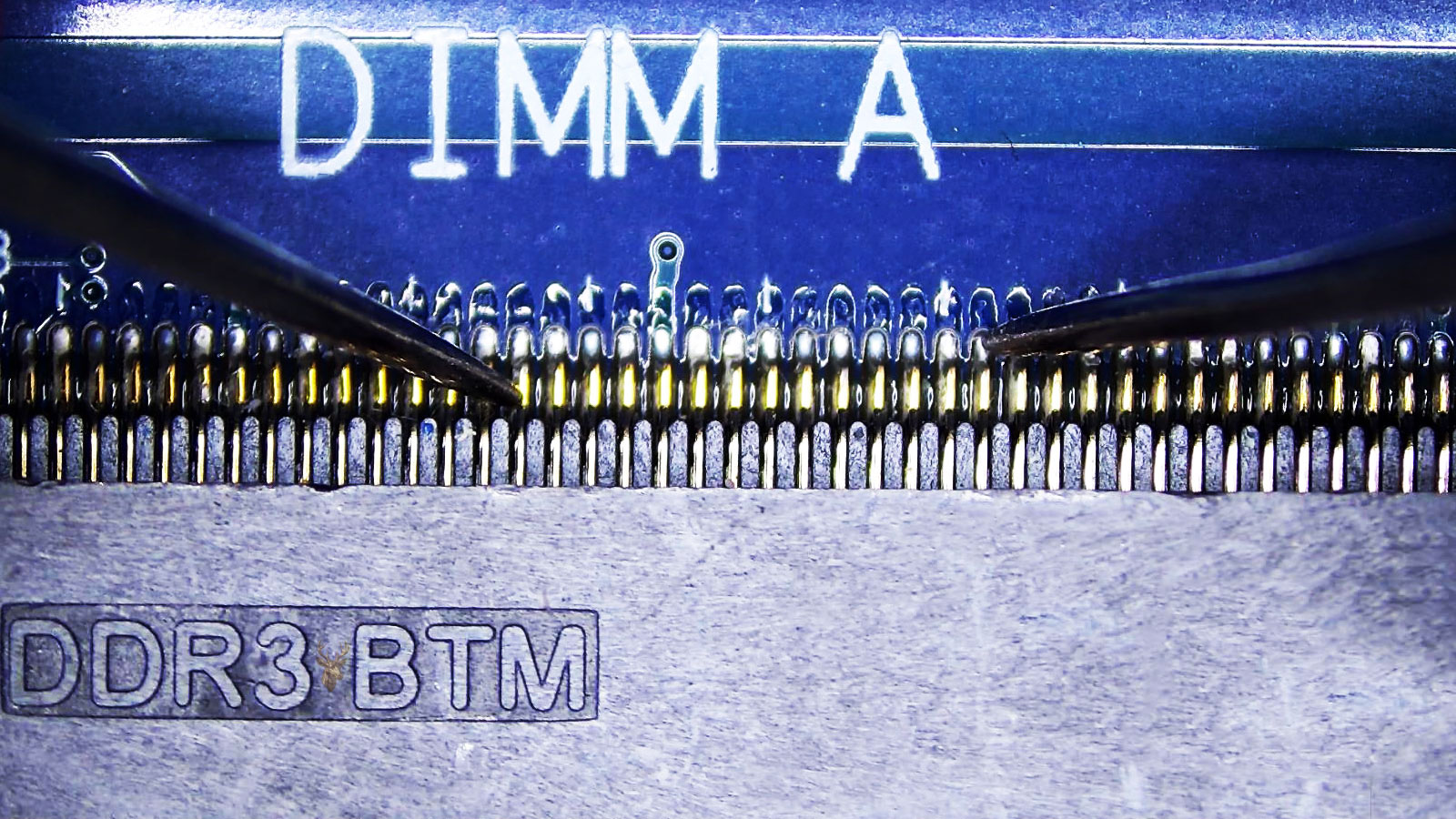 Close-up of a computer circuit board with the DIMM A DDR3 memory socket being probed at several connector pins.