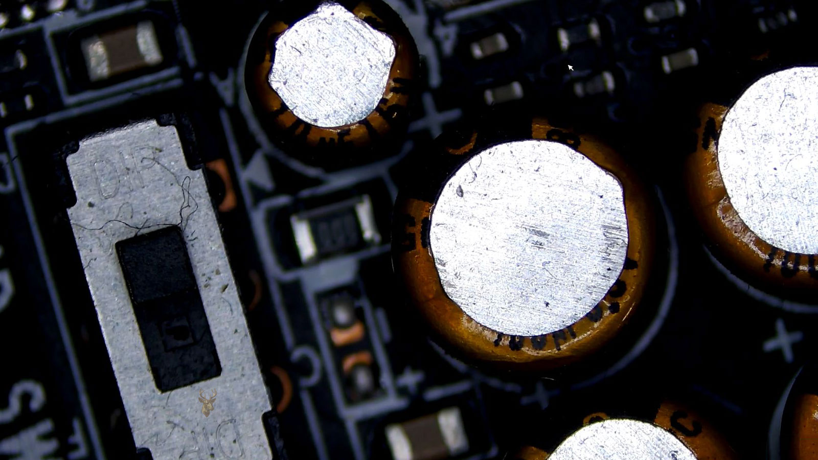 Audio SW1 section of a computer circuit board showing capacitors, a 000 fuse, a switch, and surrounding electronic components from a different angle.