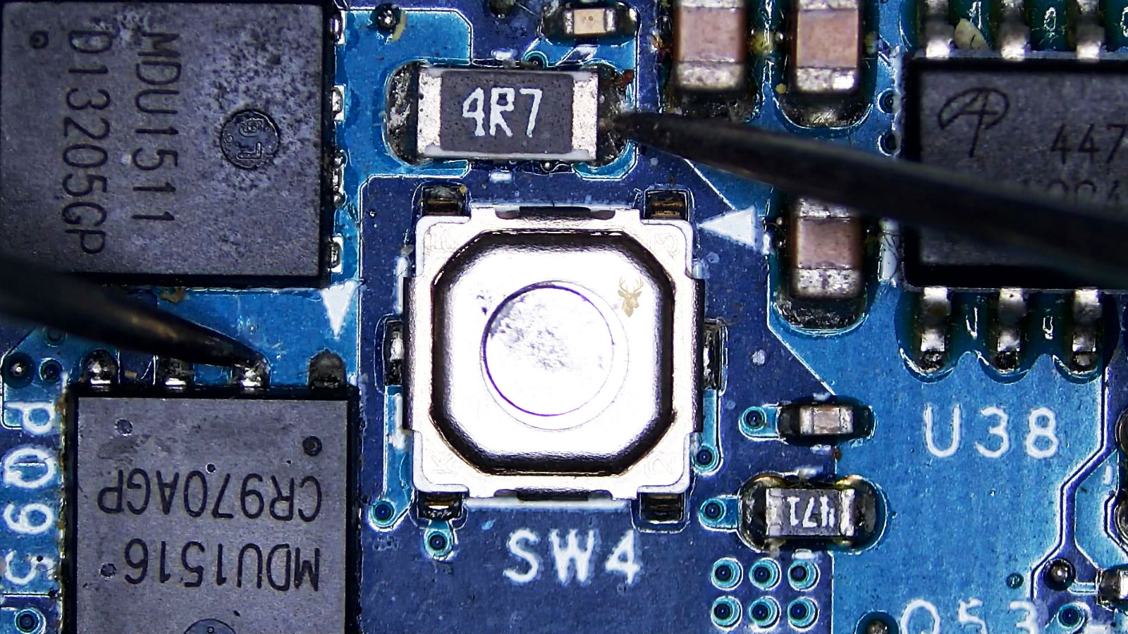 Multimeter probes testing a MOSFET and a 4R7 resistor on a computer circuit board with surrounding electronic components.