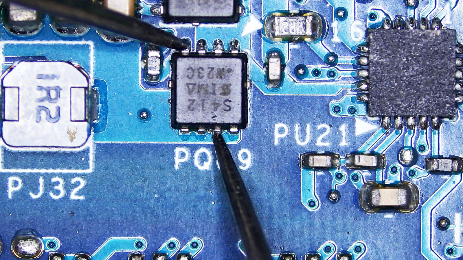 Multimeter probes testing the gate and drain of a PQ89 MOSFET on a computer circuit board with surrounding electronic components.