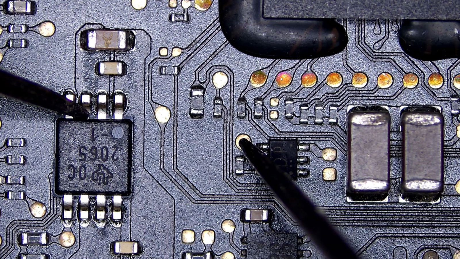 2065 IC being measured from one leg to a circuit board pad near a large processor chip and capacitors.