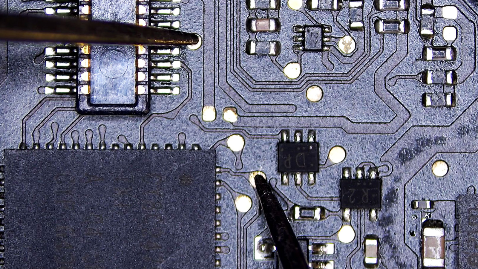 Multimeter measuring between a test pad beside the 40-pin connector and another test pad near the large processor IC.