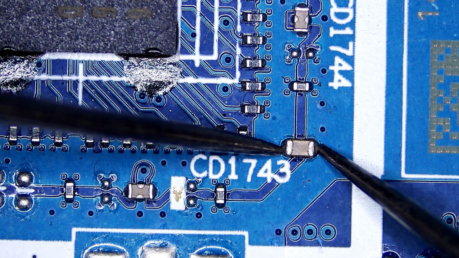 Multimeter measuring a capacitor next to the CD1743 main IC processor.