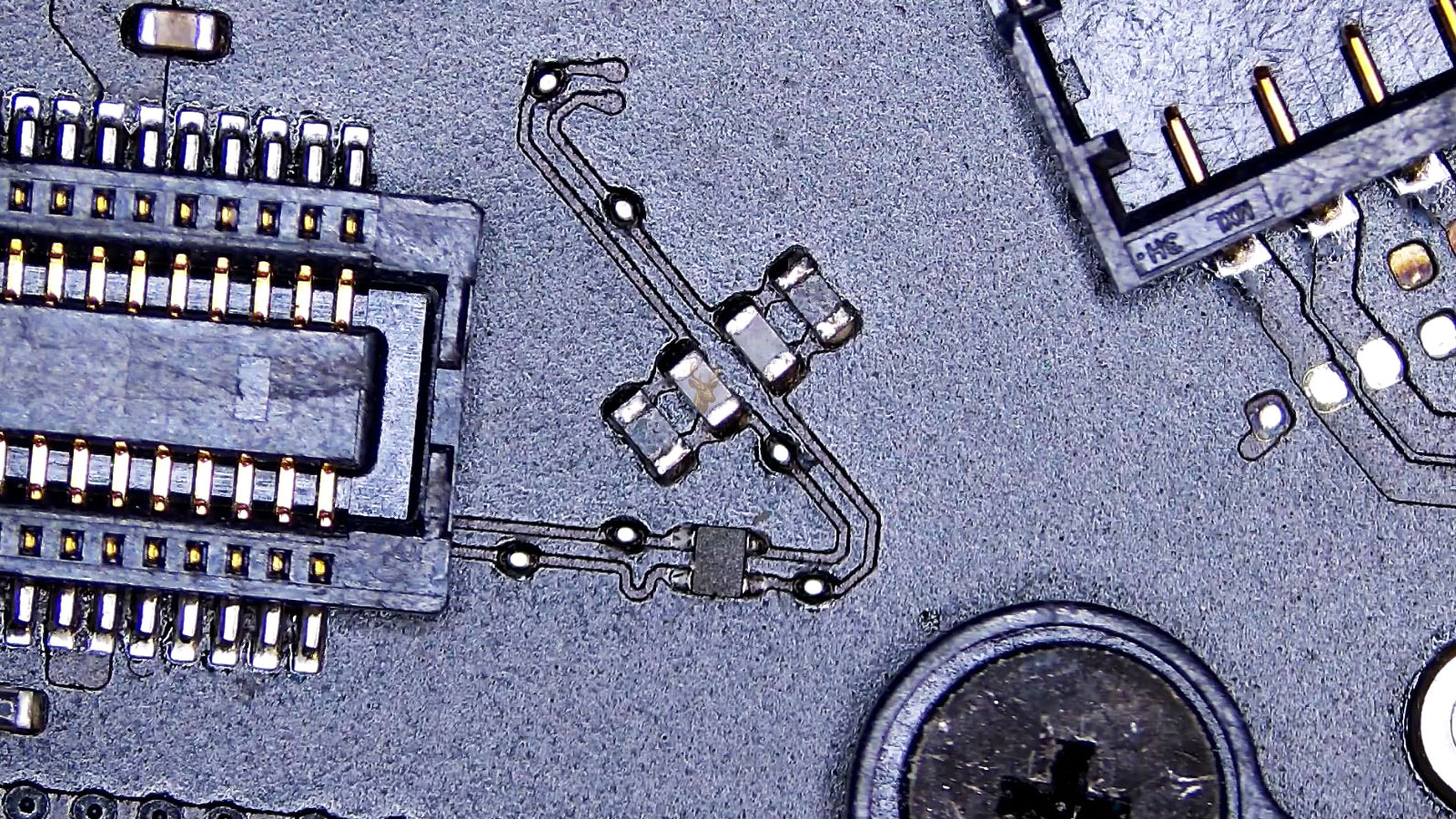 Close-up of a complex circuit board connector with cables, capacitors, and resistors.