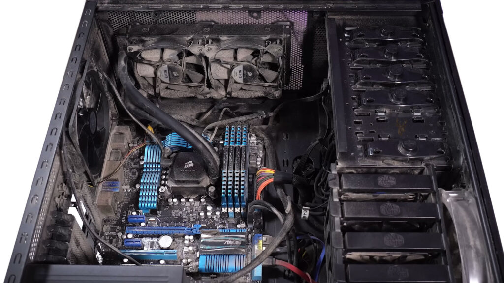 Open desktop computer with visible dust buildup inside during routine preventive maintenance.