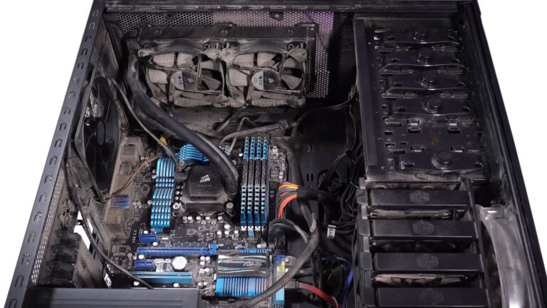 Open desktop computer with visible dust buildup inside during routine preventive maintenance.
