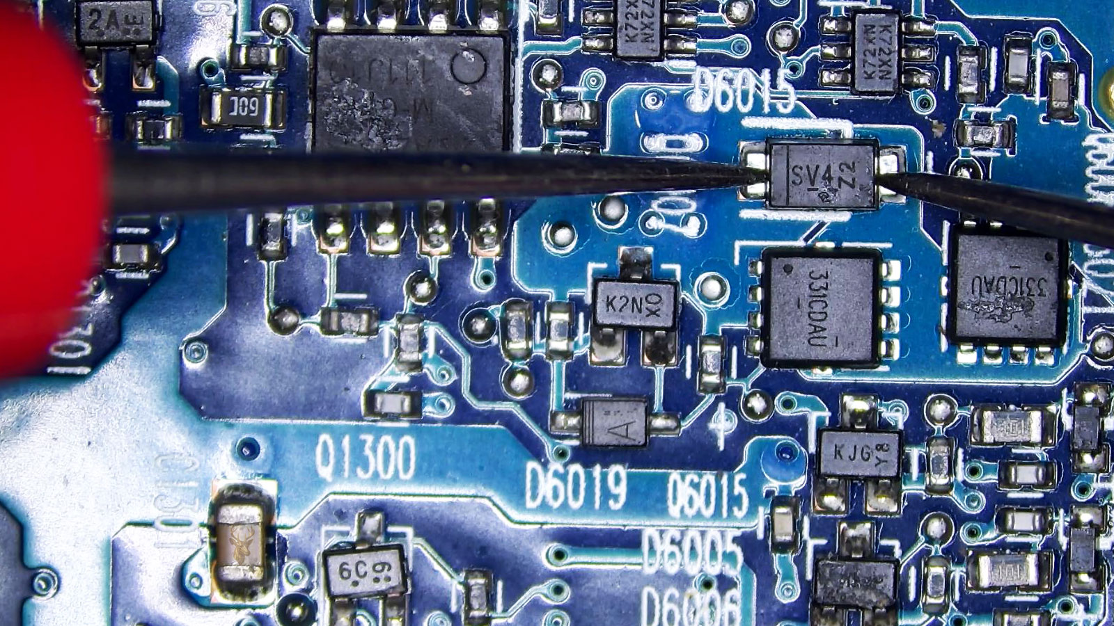 D6015 diode being measured in a busy circuit section with transistors, MOSFETs, resistors, IC chips, and power controllers.