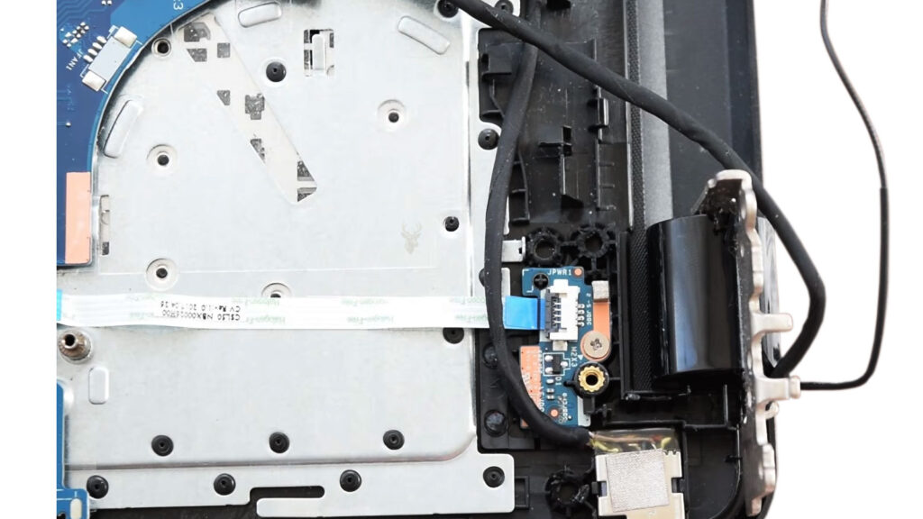 Damaged laptop hinge with the internal hinge assembly exposed before repair.