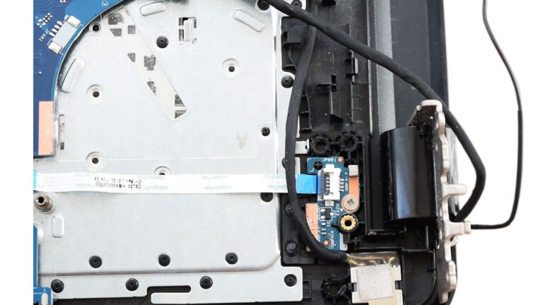 Damaged laptop hinge with the internal hinge assembly exposed before repair.