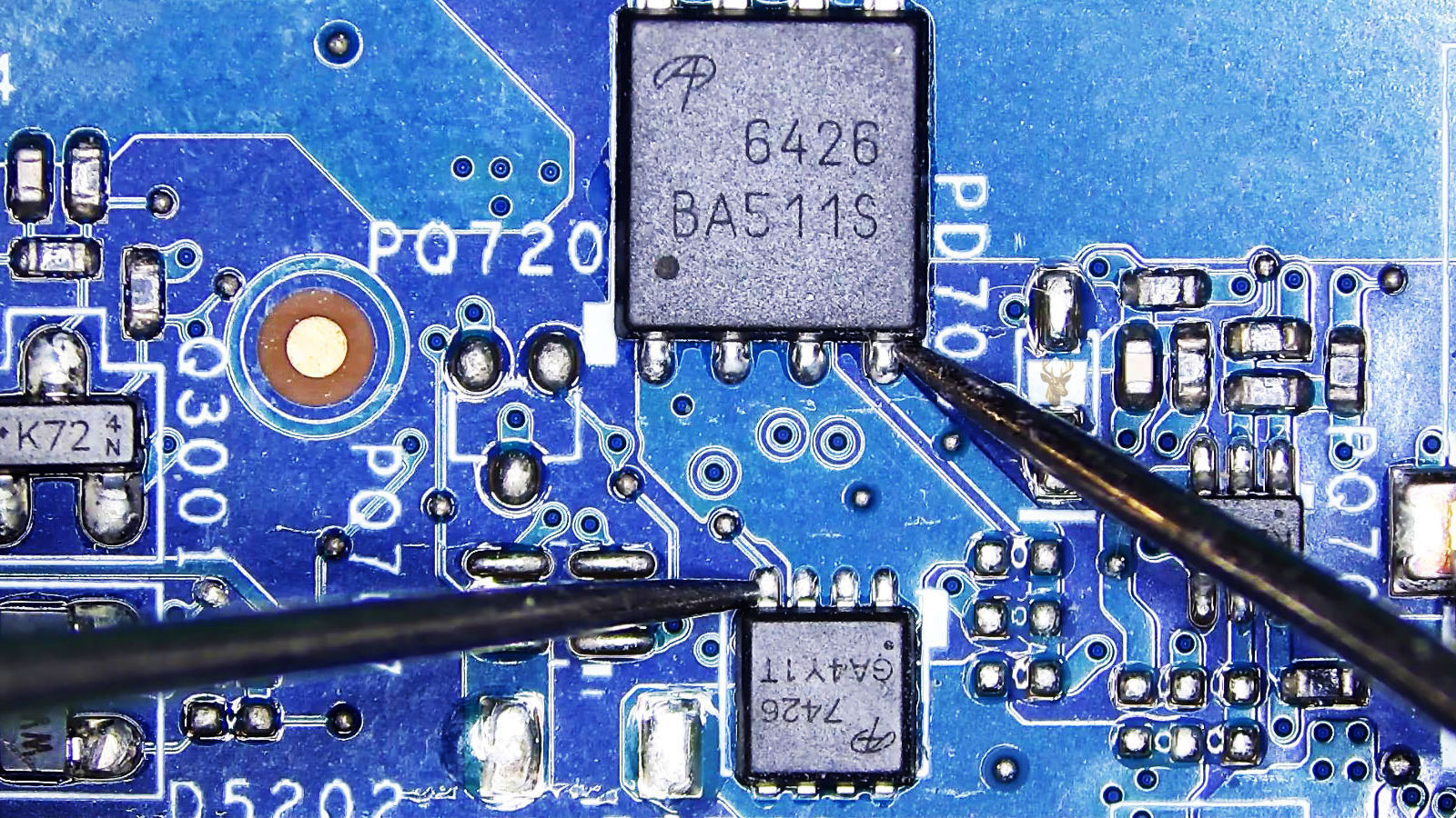 Multimeter probes measuring between the gate of the larger A6426 MOSFET and the gate of the smaller A7426 MOSFET in a crowded circuit section.