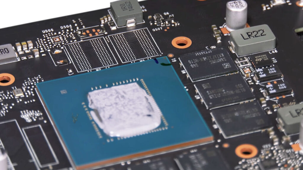 Graphics card with the heatsink removed, exposing the GPU processor and surrounding VRAM memory chips.