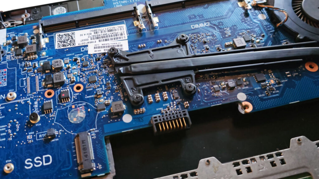 Open laptop showing the motherboard and battery connector during troubleshooting of intermittent power loss.
