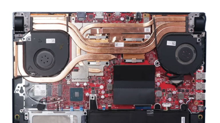 Gaming laptop with the bottom cover removed, showing the CPU and GPU heatsink assembly and dual cooling fans during overheating diagnosis.