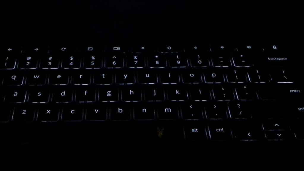 Laptop keyboard with uneven backlight illumination, showing several keys without white backlighting.
