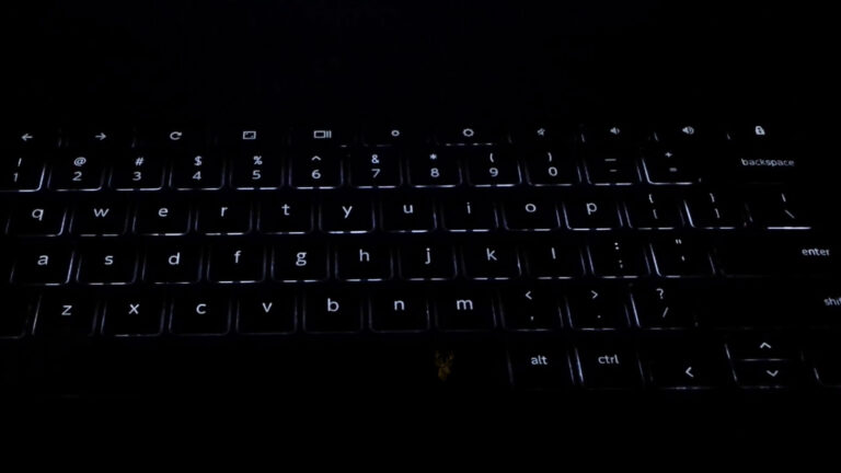 Laptop keyboard with uneven backlight illumination, showing several keys without white backlighting.