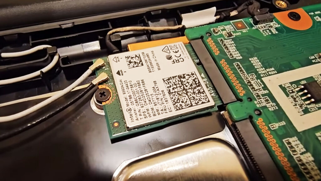 Laptop Wi-Fi antenna cables connected to the wireless card, illustrating antenna routing that can affect signal strength after a screen replacement.