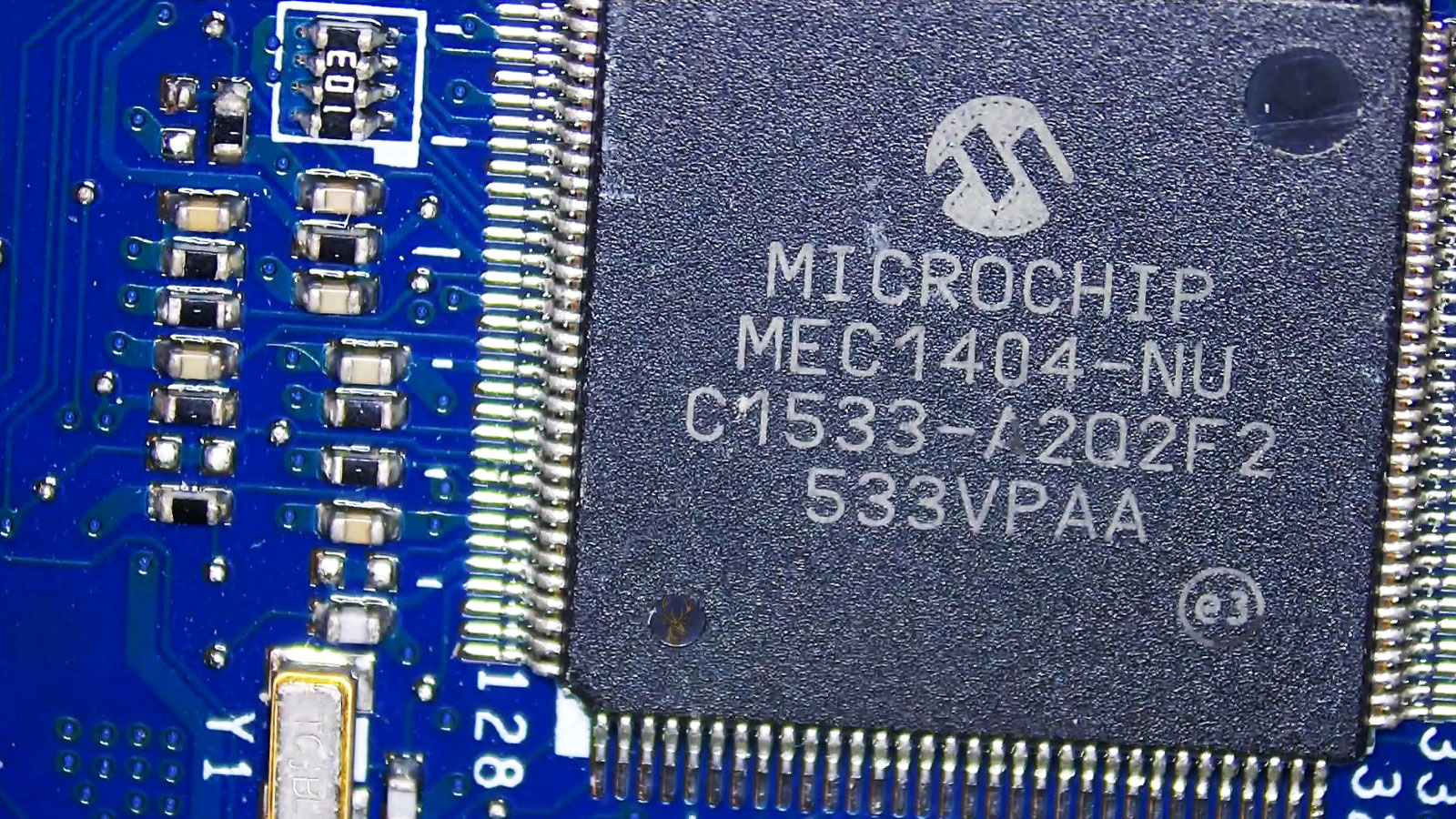 Large MEC1404NU microchip centered on a computer circuit board with several surrounding components.