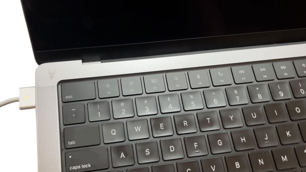 Mac laptop with the charging cable connected and the orange charging indicator illuminated, but the battery is not charging.