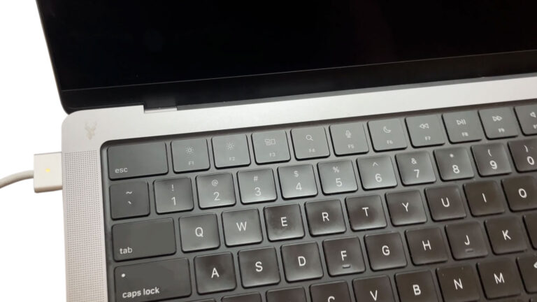 Mac laptop with the charging cable connected and the orange charging indicator illuminated, but the battery is not charging.
