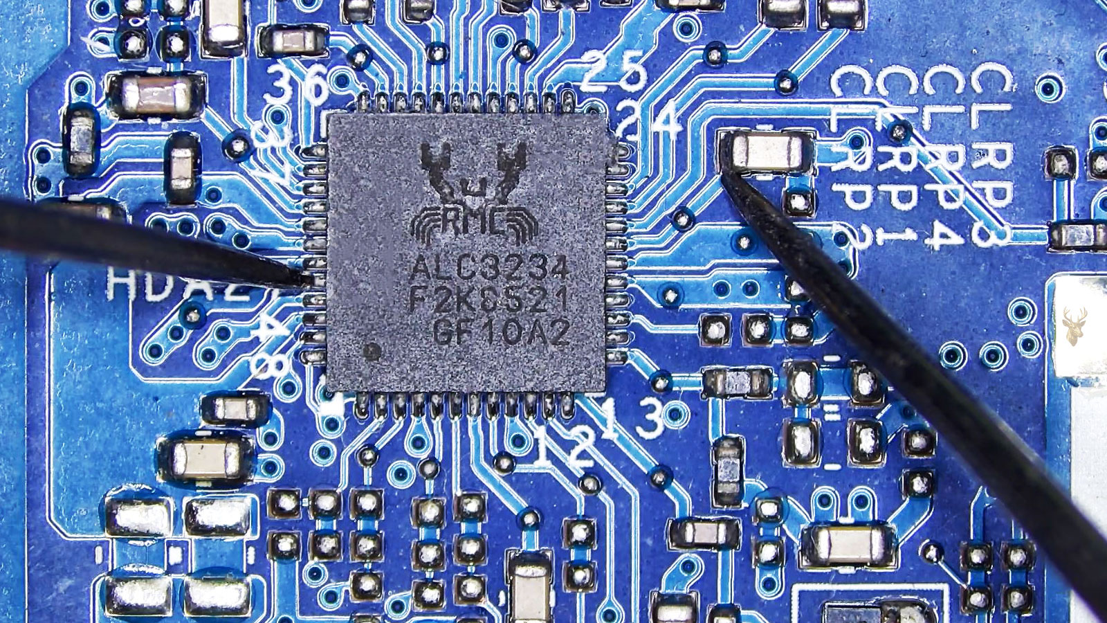 Multimeter probes measuring between one leg of the Realtek ALC3234 IC and a capacitor connected near the opposite side of the chip.