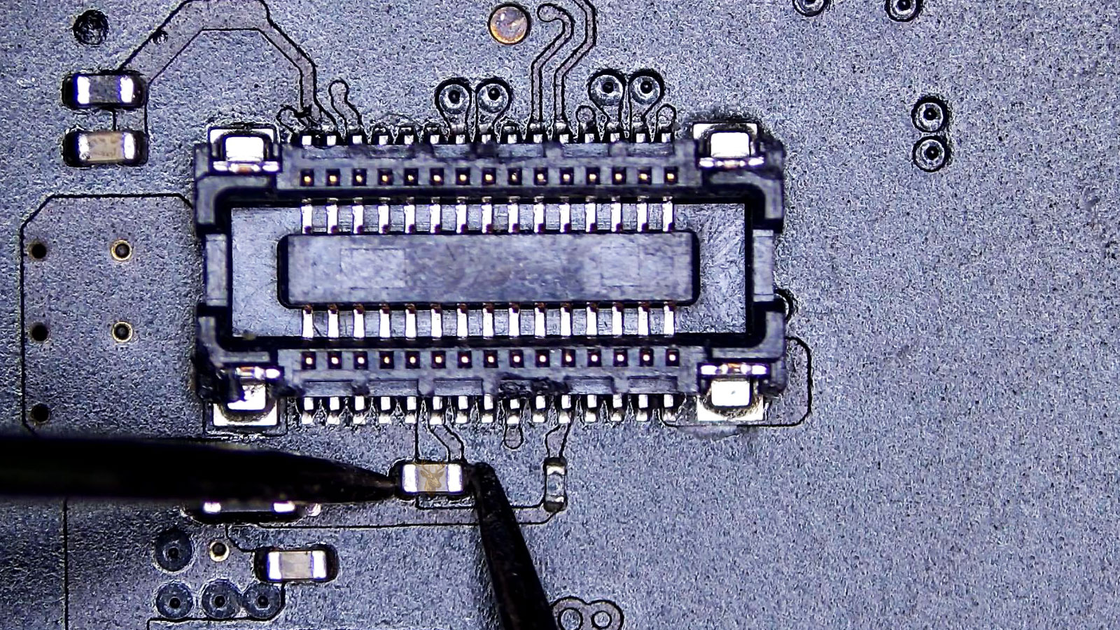 SMD capacitor being measured next to the 30-pin flat cable connector.