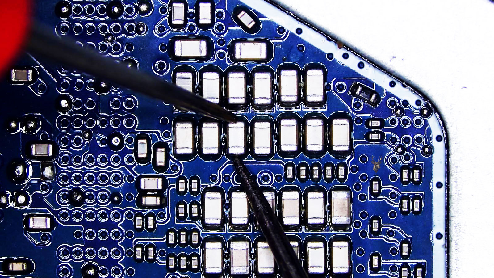 Back side of the CPU area on a circuit board filled with rows of SMD capacitors packed closely together.