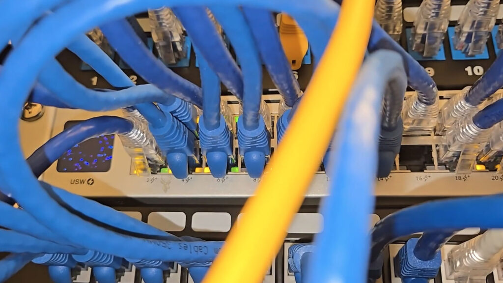 Three network switches with multiple Ethernet cables connected during a broadcast storm or network loop.