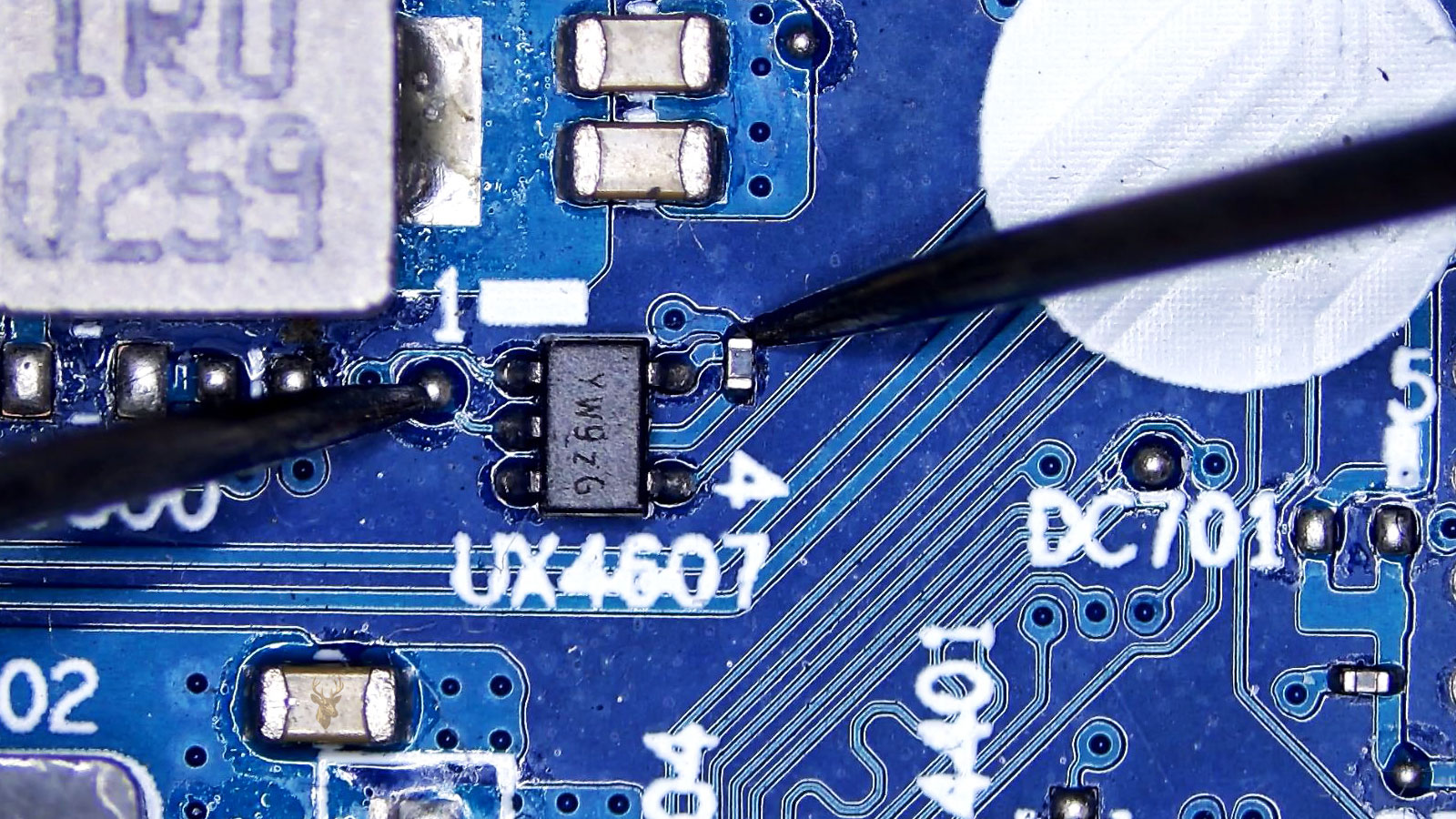 UX4607 power transistor being measured between a connected circuit pad and a small capacitor tied to one of the transistor legs