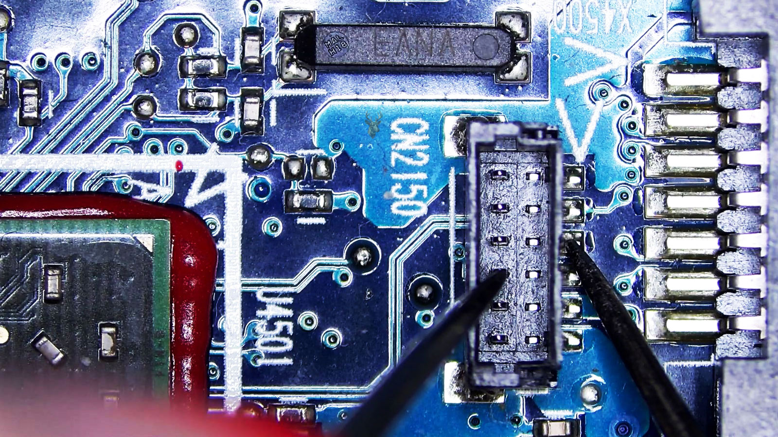 Video chip beside two connectors and a long resistor, with a center connector pin being measured against a soldered board pin.