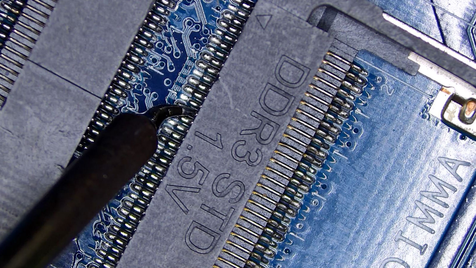 DDR3 memory socket being repaired with precision microsoldering on a connector pin.