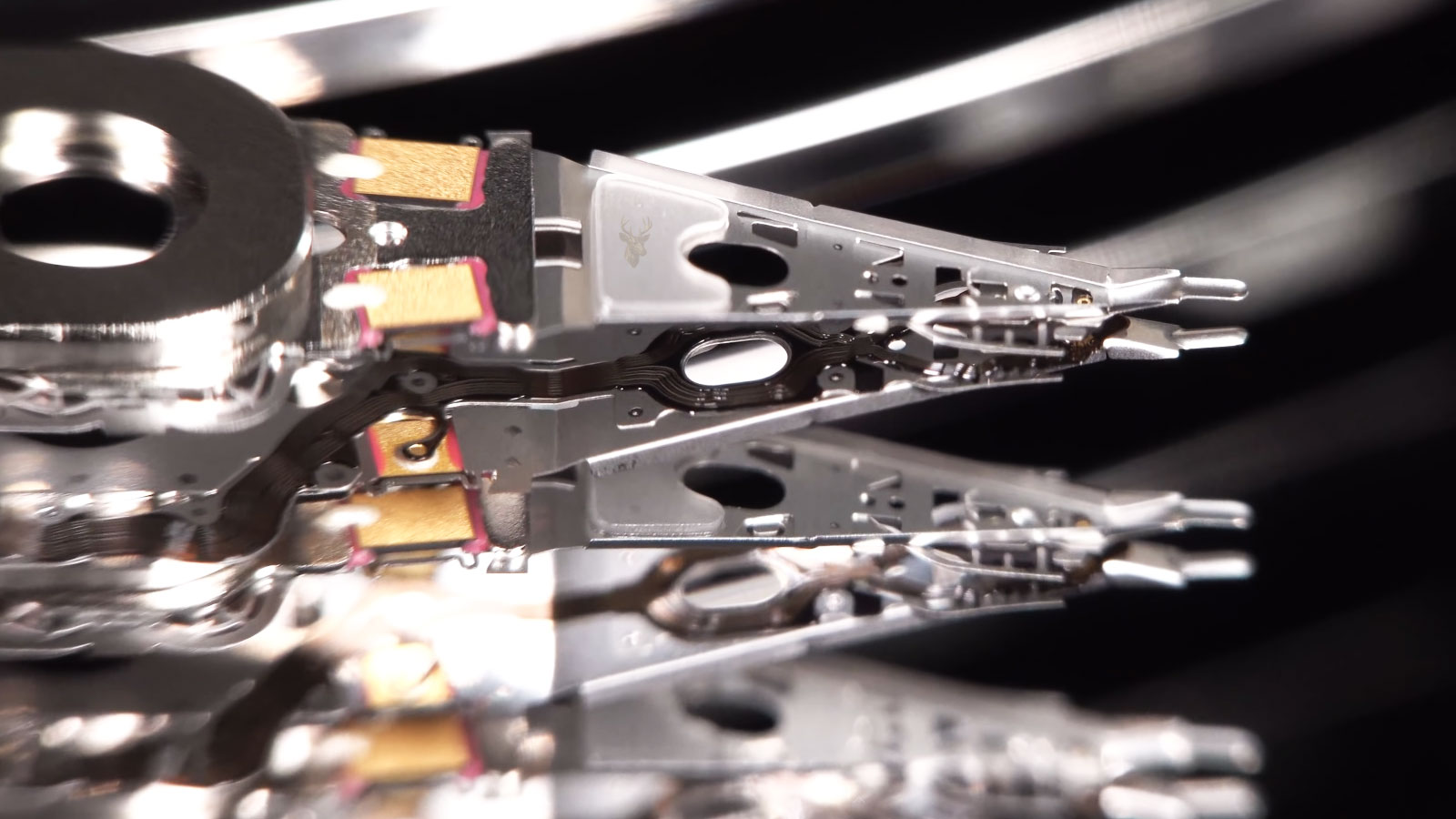 Hard drive read and write head assembly being removed during a data recovery procedure.