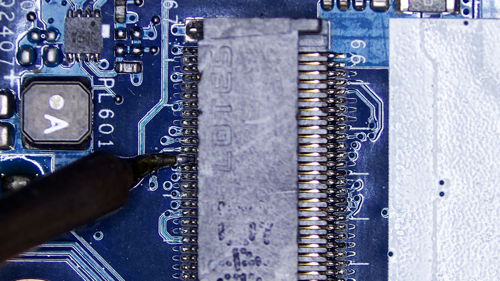M.2 socket being repaired with precision microsoldering on its connector pins.
