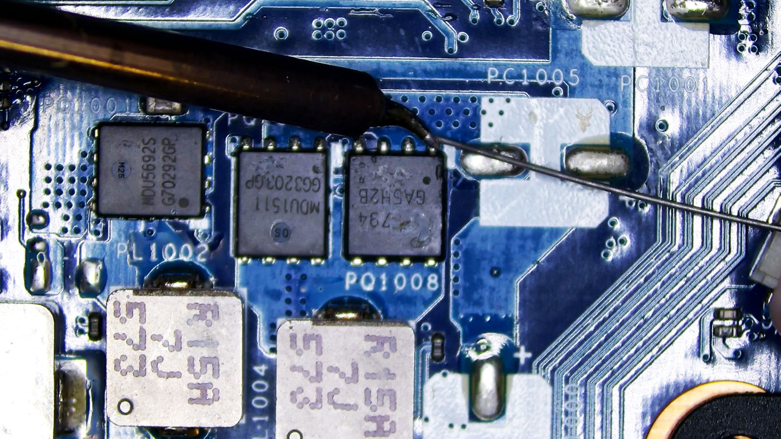 Microsoldering repair on a MOSFET pin using precision soldering equipment.