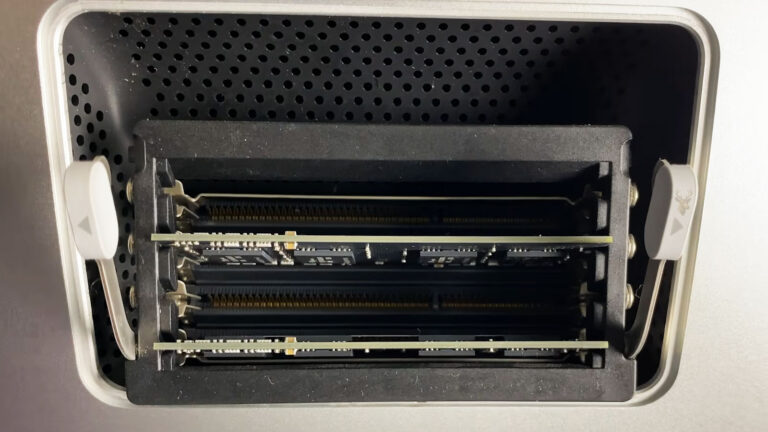 2013 iMac with the rear memory access door open while additional RAM modules are being installed to increase the system's memory capacity.
