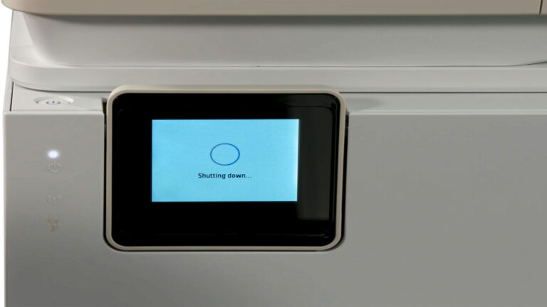 Printer displaying a Shutting Down message on its LCD screen during troubleshooting of connection and print queue problems.