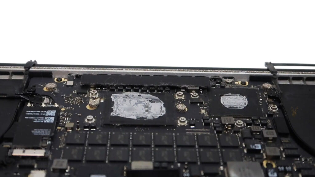 MacBook Pro 2015 with dried thermal paste on the CPU and GPU before replacement during cooling system maintenance.