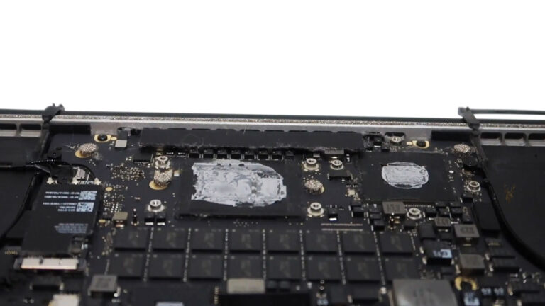 MacBook Pro 2015 with dried thermal paste on the CPU and GPU before replacement during cooling system maintenance.