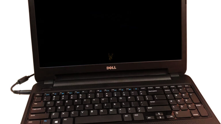 Dell laptop connected to its power adapter while charging with the system powered off.